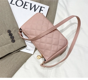 Detail of pink quilted PU leather small square bag with elegant golden zipper and thin strap