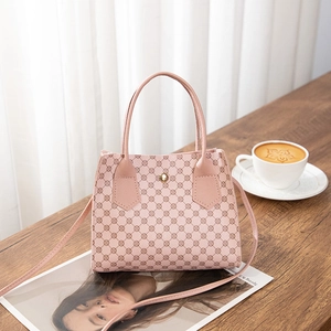 Detailed close-up of pink geometric pattern handbag with golden metal buckle on wood