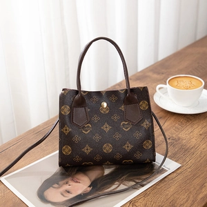 Vintage dark brown crossbody handbag with clover pattern on a wooden tabletop