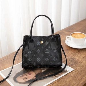 Top-down view of black handbag with vintage floral print on a cozy wooden table