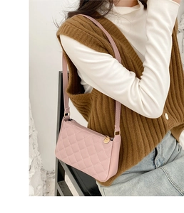 Detailed close-up of pink quilted underarm bag with gold ring zipper and leather strap