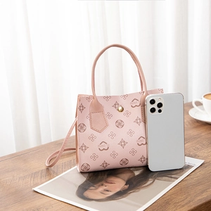 Mini pink monogram handbag with slim shoulder strap shown next to a smartphone