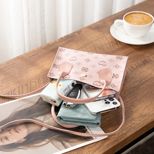 Detail of pink printed mini handbag showing capacity for phone, wallet and cosmetics