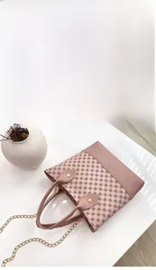 Detailed view of pink patterned PVC hobo bag with gold chain strap and sturdy leather handle