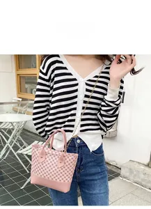 Detailed view of pink hobo bag with contrast geometric patterns and gold chain strap