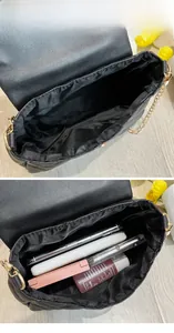 Detail view of the quilted black shoulder bag showing internal capacity and gold chain