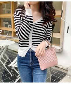 Pink printed hobo bag with gold chain strap shown with casual striped cardigan outfit