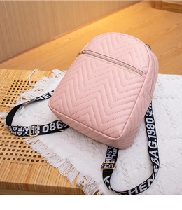 Close-up of pink chevron quilted mini backpack with stylish lettered woven shoulder straps