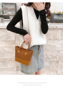 Close-up of vintage brown pattern hobo bag with gold metal chain and dual handles
