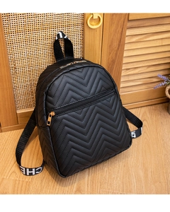 Detail of black mini backpack featuring V-shaped quilting and logo webbed straps