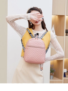 Detail of pink quilted V-pattern backpack with branded logo woven straps for women