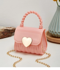 Detail of pink jelly bag featuring a gold heart clasp and twisted handle design