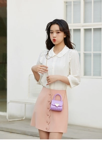 Detail of lavender jelly mini bag with heart hardware and elegant gold chain strap
