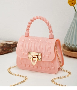 Detailed close-up of a pink PVC mini jelly bag with gold rivets and chain strap