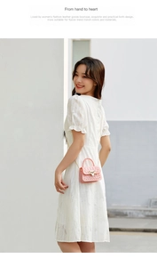 Close-up of light pink mini jelly crossbody bag with gold chain and rivet details