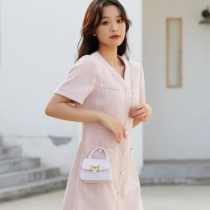 Mini white PVC jelly bag with gold rivets and chain strap, worn with a pink tweed dress