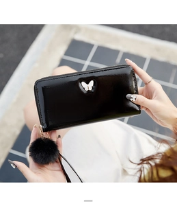 Glossy black long wallet with white butterfly metal buckle and soft pompom charm