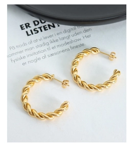 Detailed view of gold twisted rope hoop earrings with a polished metallic finish