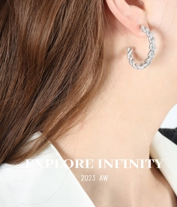 Silver twisted C-shape earrings with woven texture worn by model for style