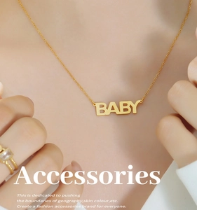 Dettaglio di una collana con pendente Baby placcata in oro su una modella per donne