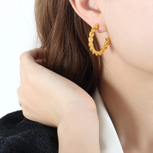 French style chunky twisted hoop earrings in 18k gold plated stainless steel on model