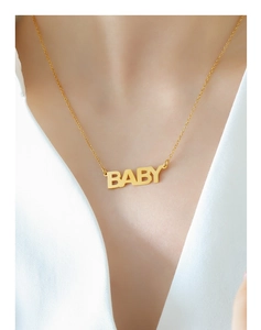Dettaglio di una collana con ciondolo Baby in oro indossata per mostrare la lavorazione