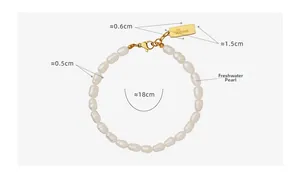 Dettaglio macro della piastrina dorata Love e perle barocche bianche del bracciale