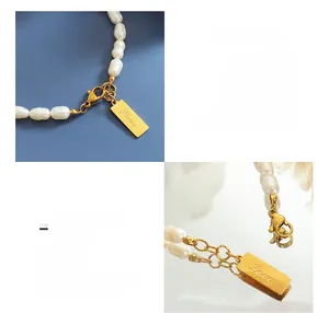 Dettaglio macro del ciondolo quadrato con incisione LOVE su bracciale di perle dorato