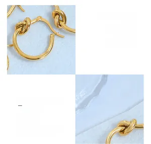 Détail macro du design à nœud sur boucles d'oreilles en titane avec placage or 18k