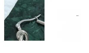 Détail macro du fermoir de boucle d'oreille en acier poli sur fond de marbre