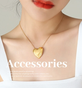 Primer plano de un collar con colgante de corazón de oro pulido llevado por una modelo
