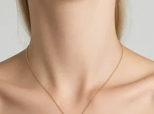 Close-up of golden snake chain necklace on model's neck with polished metallic texture