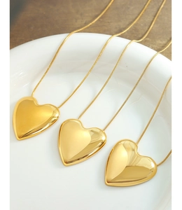 Tres collares con colgante de corazón dorado y cadena de serpiente en bandeja cerámica