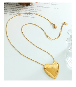 Detalle del colgante de corazón dorado en cadena de serpiente con sello K18 y cierre