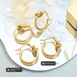 Boucles d'oreilles nœuds minimalistes plaquées or 18 carats sur boîte à bijoux