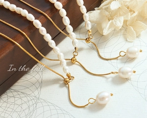 Macro detail of freshwater pearl necklace with 18K gold-plated snake chain and drop charm