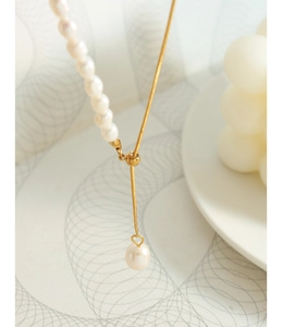 Close-up of a gold snake chain with freshwater pearls and adjustable slider clasp