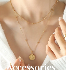 Detail of 18k gold layered necklace with evil eye pendant and beaded chain design