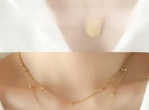 Close-up of double-layered 18k gold-plated beaded necklace on model neck