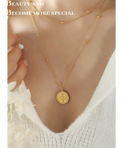 Detail view of 18k gold plated double layer necklace with evil eye coin pendant