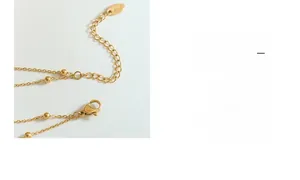 Detail of lobster clasp and K18 hallmark on the gold-plated beaded double layer necklace