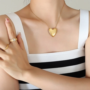Conjunto de collar con colgante de corazón dorado pulido y anillos a juego
