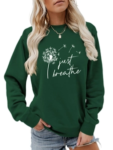 Détail de l'imprimé Just Breathe et du motif pissenlit sur le sweat-shirt vert foncé