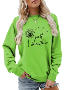 Détail du sweat-shirt vert clair avec motif pissenlit et texte Just Breathe brodé