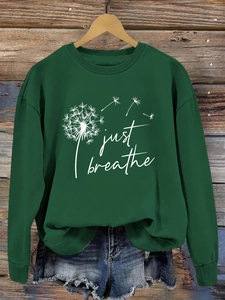 Détail de l'imprimé pissenlit Just Breathe sur tissu de sweat en coton vert foncé
