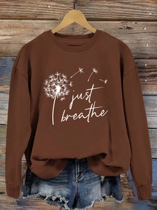 Détail de l'imprimé pissenlit Just Breathe sur un sweat-shirt marron à manches longues