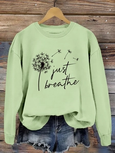 Détail de l'imprimé pissenlit Just Breathe sur un sweat-shirt vert menthe à manches