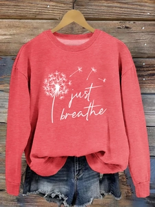 Détail de l'imprimé pissenlit Just Breathe sur un sweat-shirt rouge à manches longues