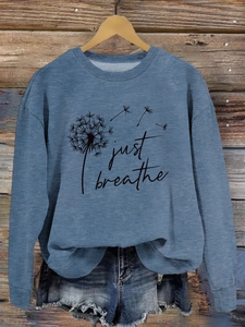 Détail de l'imprimé pissenlit Just Breathe sur un sweat bleu avec un short en jean