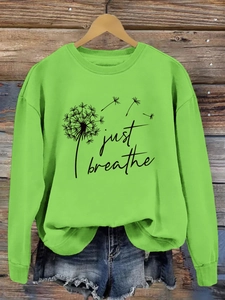 Détail de l'imprimé pissenlit Just Breathe sur un sweat-shirt vert à manches longues
